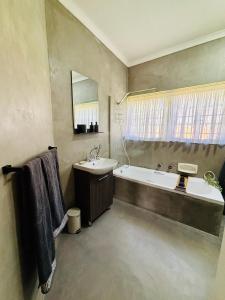 a bathroom with a bath tub and a sink and a bath tub at Homestead in Kempton Park +34 photos