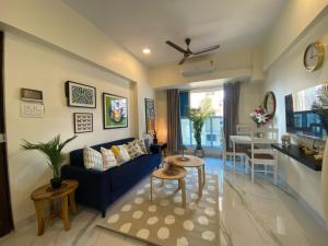 a living room with a blue couch and a table at Sheetal Vaibhav 902 in Mumbai
