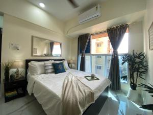 a bedroom with a large bed and a window at Sheetal Vaibhav 902 in Mumbai