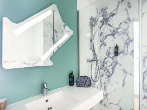 a bathroom with a sink and a shower at ibis budget Nancy Porte Sud in Houdemont +50 photos