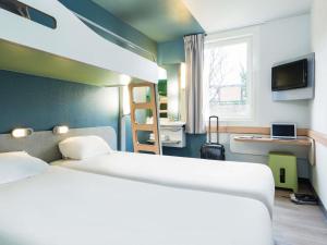a hotel room with a bed and a window at ibis budget Paris Porte De Montmartre in Paris +42 photos