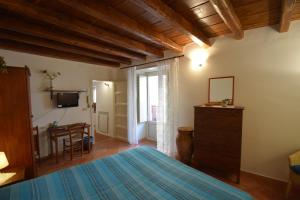 a bedroom with a bed and a television and a table at Casa Vacanza Alma in Cefalù