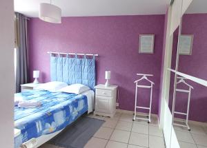 a bedroom with purple walls and a bed and a ladder at Appartement Royat 2 pers Romeuf in Royat +1 photo