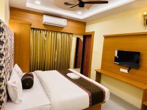 a hotel room with a bed and a flat screen tv at Hotel Rajwada Nagpur in Nagpur +18 photos