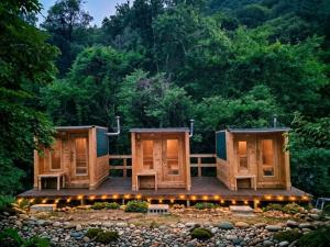 two modular homes on a deck with trees in the background at Gapyeong Vistahill Pension in Gapyeong