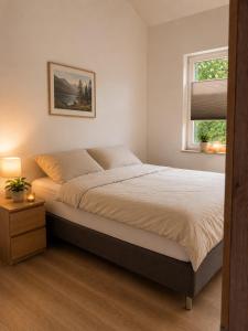 a bedroom with a large bed and a window at Ferienhäuser Seetraum - Premium Card inklusive in Weissensee