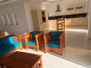 a living room with a table and chairs and a kitchen at Villa pieds dans l'eau, magnifique terrasse face à la mer in Zarzis