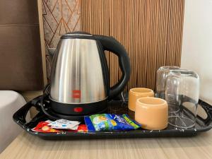 a tea kettle on a tray on a table at Hotel Pratishtha in Rishīkesh