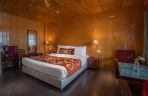 a bedroom with a large bed in a room with wooden walls at Summit Tashi Ghang Heritage Resort in Pelling +59 photos