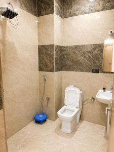 a bathroom with a toilet and a sink at Hotel Pratishtha in Rishīkesh +6 photos