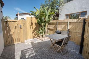 a patio with a wooden fence and a table at 3 Pepper Street by African Perfection in Jeffreys Bay