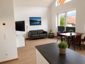 a living room with a couch and a table at Ferienhäuser Seetraum - Premium Card inklusive in Weissensee