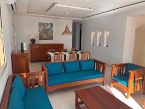 a living room with two chairs and a blue couch at Villa pieds dans l'eau, magnifique terrasse face à la mer in Zarzis