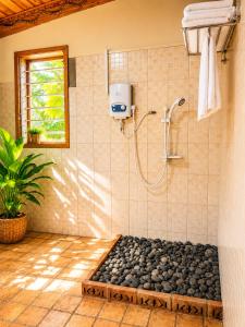 a bathroom with a shower with a pile of rocks at Voyager's Center in Kikorongo +52 photos