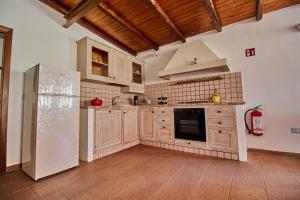a kitchen with wooden cabinets and a refrigerator at Casa Cesare - appartamenti a Salina in Isola Salina