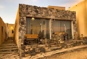 a stone building with benches on a street at SAMA Al Khutaim-Heritage Home in Nizwa +10 photos
