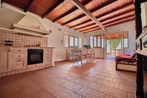 a kitchen with wooden ceilings and a table and chairs at Casa Cesare - appartamenti a Salina in Isola Salina +22 photos