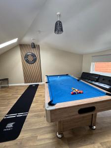 a room with a pool table and a clock on the wall at Gladstone Getaway in Peterhead