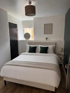 a bedroom with a large white bed with green pillows at Gladstone Getaway in Peterhead