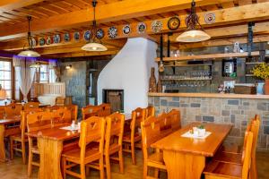 a restaurant with wooden tables and chairs and a bar at Salaš Vígľaš in Bojnice