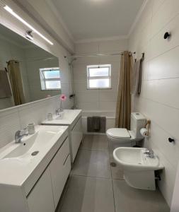 a white bathroom with two sinks and a toilet at Sunset Paradise in Armação de Pêra +16 photos