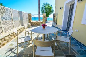 a table and chairs on a balcony with the ocean at Thalassa Seaside Apartments in Sikéa