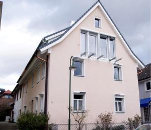 una casa blanca con techo inclinado en Haus Rebstein, en Immenstaad am Bodensee