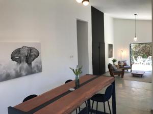 a dining room with a table and a picture of an elephant at Birdsong Bungalow in Livingstone