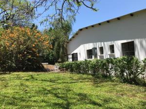 a white house with a yard in front of it at Birdsong Bungalow in Livingstone