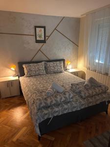a bedroom with a bed with two towels on it at Green Garden Apartments in Surčin