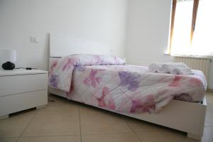 a white bedroom with a bed and a dresser at Casa di Nonna Angela in Guadamello