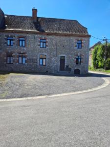 an old stone house with a driveway in front of it at Le Fond du Village in Solre-Saint-Géry