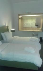 a hotel room with a large bed with white sheets at Le Margherite in Kalkara