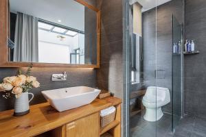 a bathroom with a sink and a shower and a toilet at 鹿野山房 DeerHoliday Inn in Dali +23 photos