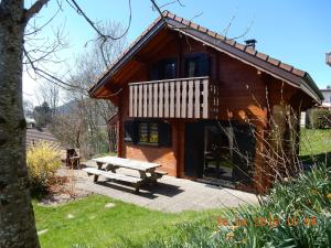 a wooden cabin with a picnic bench in front of it at Chalet pour 2 personnes à 700m du Centre Ville in Gérardmer