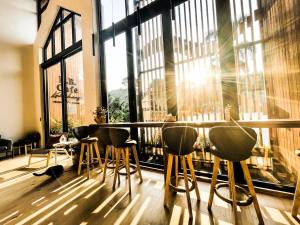 a bar with stools in a room with large windows at K.B. Resort in Ko Chang