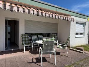 a patio with chairs and a table and an awning at Sonnenblick Kleiberweg in Mosbach