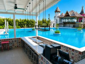 an empty pool at a resort with chairs and a bar at Anapea Village in Tkhilistskaro