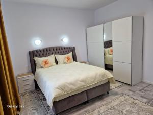 a bedroom with a large bed and a mirror at Apartament 3D in Fălticeni