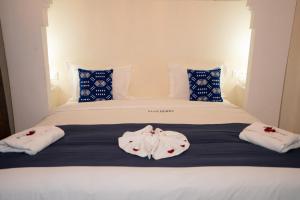 a bedroom with a bed with two towels on it at Riad Blue Berry & SPA in Marrakesh