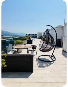 a patio with a swing and a table on a roof at Rainbow Residence Batumi in Batumi
