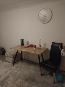 a table with a chair and a clock on the wall at Cozy Apartment Koblenz in Koblenz +2 photos