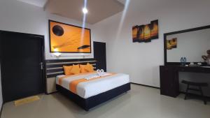 a bedroom with a bed and a painting on the wall at Melaya Beach Resort Queen Bed in Penginuman