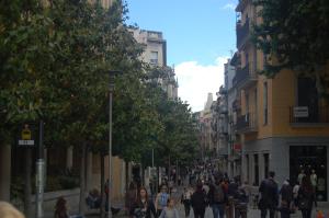 a group of people walking down a city street at Hortes 7 in Girona