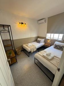 a small room with two beds and a table at Casa en el centro de Nerja- Calle Nueva 21 in Nerja