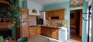 a kitchen with wooden cabinets and a counter top at Métro - Sac à dos - Dodo Chez Léontine 2 chambres Parking Wifi in Colombes