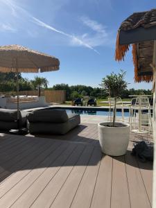 a wooden deck with chairs and a swimming pool at Suite Vendôme - Elégance, Terrasse avec accès Piscine in Villeréal