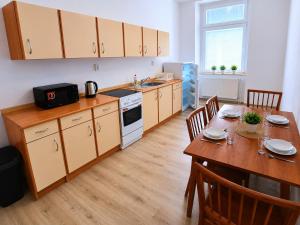 a kitchen with a table and a dining room at Apartmány Pražská in Ústí nad Labem +25 photos