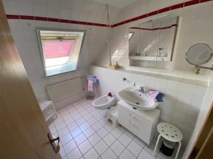 a white bathroom with a sink and a mirror at Ferienwohnung-Wildblume in Petersdorf auf Fehmarn