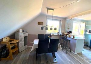 a kitchen and living room with a table and chairs at Ferienwohnung-Wildblume in Petersdorf auf Fehmarn +11 photos